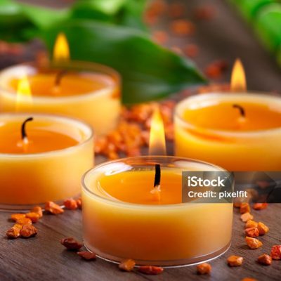 Four orange lit candles arrangement